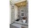 Home's entryway with stone facade, a white door with a small window, and a welcome mat at 10207 Xanadu St, Commerce City, CO 80022