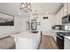 Modern kitchen with a large island with quartz countertops, stainless steel appliances, and wood flooring at 10207 Xanadu St, Commerce City, CO 80022