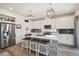 Kitchen featuring white cabinets, stylish pendant lighting and stainless steel appliances at 10207 Xanadu St, Commerce City, CO 80022