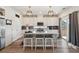 Stylish kitchen featuring white cabinets, stylish pendant lighting, and stainless steel appliances at 10207 Xanadu St, Commerce City, CO 80022