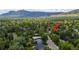 An aerial view of a property in a neighborhood surrounded by lush greenery and mountain views at 3545 Cloverleaf Dr, Boulder, CO 80304