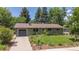 Charming single-story home with a lush green lawn, mature trees, and an attached garage at 3545 Cloverleaf Dr, Boulder, CO 80304