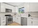Bright kitchen features white cabinets, stainless steel appliances, and a sunlit window at 3545 Cloverleaf Dr, Boulder, CO 80304