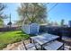 Spacious backyard with a deck, patio furniture, well-manicured lawn, and a convenient storage shed at 4920 Clay St, Denver, CO 80221