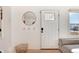 Inviting entryway with a white door, coat hooks, and decorative mirror at 4920 Clay St, Denver, CO 80221