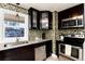 Updated kitchen with dark cabinets, stainless steel appliances, granite countertops, and mosaic tile backsplash at 4920 Clay St, Denver, CO 80221