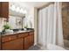Bathroom features a granite countertop, wood cabinets, a shower with tub, and modern lighting at 3343 S Monaco Pkwy # A, Denver, CO 80222