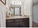 Well-lit bathroom with a granite countertop, decorative hand towels and dark wood cabinets at 3343 S Monaco Pkwy # A, Denver, CO 80222