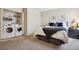 Cozy bedroom featuring a washer, dryer, soft carpet and a bed with stylish pillows and framed wall art at 3343 S Monaco Pkwy # A, Denver, CO 80222