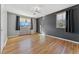 A bedroom featuring hardwood floors, painted walls, and two windows with dark curtains at 525 Jackson St # 304, Denver, CO 80206