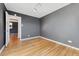An empty bedroom featuring hardwood floors, painted walls, base molding, and a doorway to another room at 525 Jackson St # 304, Denver, CO 80206