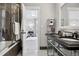 Bathroom with black vanity, dual sinks, tub/shower combo with dark tile, and a view into the bedroom at 4475 S Downing St, Cherry Hills Village, CO 80113