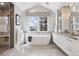 Bright bathroom with a large soaking tub under a window and double vanity sinks at 4475 S Downing St, Cherry Hills Village, CO 80113