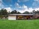 Unique home with expansive windows, a well-manicured lawn, and mature trees at 4475 S Downing St, Cherry Hills Village, CO 80113