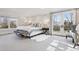 Bright main bedroom featuring a king bed, bench seating, and French doors to a balcony at 4475 S Downing St, Cherry Hills Village, CO 80113