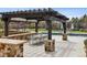 Outdoor dining and pool area with pergola, stone pillars, large dining table and lounge chairs at 4475 S Downing St, Cherry Hills Village, CO 80113