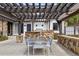 Outdoor kitchen and dining area with a pergola, stone counter and seating for 10 at 4475 S Downing St, Cherry Hills Village, CO 80113