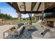 Spacious outdoor patio area with stone fireplace, comfortable seating, and a beautiful backyard view at 4475 S Downing St, Cherry Hills Village, CO 80113