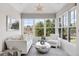 Bright sunroom with white furniture, large windows offering a view of the outdoor greenery at 4475 S Downing St, Cherry Hills Village, CO 80113