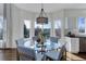Sunny dining area with a modern light fixture and a glass-top table surrounded by comfortable seating at 22388 Quail Run Dr, Parker, CO 80138