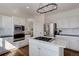 Open kitchen features white cabinetry, a stainless refrigerator, and an island with a gas cooktop at 22388 Quail Run Dr, Parker, CO 80138