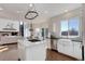 Open concept kitchen with white cabinets, an island cooktop, and stainless steel appliances, with a connected living space at 22388 Quail Run Dr, Parker, CO 80138