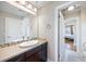 Bathroom with a large mirror, countertop sink, and a view into the bedroom at 3431 Fantasy Pl, Castle Rock, CO 80109