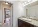 Bathroom with a large mirror, countertop sink, and a view into the bedroom at 3431 Fantasy Pl, Castle Rock, CO 80109