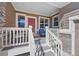 Inviting front porch featuring a cozy seating area and a charming red front door with decorative sidelights at 3431 Fantasy Pl, Castle Rock, CO 80109