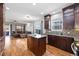 Kitchen flows into living area, featuring a large kitchen island, wood cabinets, and hardwood flooring throughout at 3431 Fantasy Pl, Castle Rock, CO 80109
