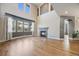 Spacious living room with soaring ceilings, a fireplace, and large windows for natural light, and hardwood floors at 3431 Fantasy Pl, Castle Rock, CO 80109