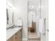 Modern bathroom with a glass shower, wood stool, white tiles and neutral color palette at 1333 Elati St # 1, Denver, CO 80204