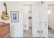 Hallway with a guitar on the wall, leading to a bathroom, with a closet and artwork visible at 1333 Elati St # 1, Denver, CO 80204