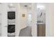 Hallway showing a stacked washer/dryer and a view of a bathroom with a modern vanity at 1333 Elati St # 1, Denver, CO 80204