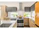 Bright kitchen featuring modern appliances, light countertops, and a stylish range hood at 1333 Elati St # 1, Denver, CO 80204