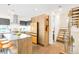 Bright kitchen featuring wooden cabinets, a kitchen island with seating, and a unique yellow refrigerator and stairs at 1333 Elati St # 1, Denver, CO 80204