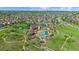 Aerial view showcases a luxurious community pool, clubhouse, and the surrounding green spaces and trails at 21392 E Stroll Ave, Parker, CO 80138
