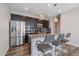 Contemporary kitchen featuring stainless steel appliances, dark cabinets, and a granite island with seating at 21392 E Stroll Ave, Parker, CO 80138