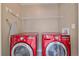 Clean laundry room featuring large, front-loading red washer and dryer at 21392 E Stroll Ave, Parker, CO 80138