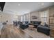 Bright living room featuring a modern sectional sofa, elegant lighting, and wood-style flooring at 21392 E Stroll Ave, Parker, CO 80138