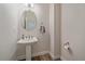 Stylish powder room featuring a pedestal sink and decorative mirror at 21392 E Stroll Ave, Parker, CO 80138