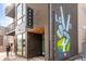 The Asher apartment building entrance with modern design and a vibrant 'Love We Can' mural at 4454 Utica St, Denver, CO 80212