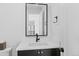 Modern bathroom featuring a sleek mirror, black hardware, white countertop, and clean design at 4454 Utica St, Denver, CO 80212