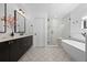 Stylish bathroom with a modern vanity, freestanding tub, and a glass-enclosed shower featuring white subway tile at 4454 Utica St, Denver, CO 80212