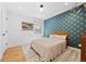 Stylish bedroom with hardwood floors, a patterned accent wall, and a cozy bed with modern decor at 4454 Utica St, Denver, CO 80212
