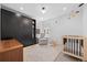 Well-lit bedroom featuring built-in wardrobe, sleek modern lighting, crib, and a cozy glider chair at 4454 Utica St, Denver, CO 80212