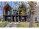 Modern two-story home with a black exterior, inviting front porch with bright red chairs, and well-maintained lawn at 4454 Utica St, Denver, CO 80212