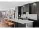 Modern kitchen boasts an oversized island with seating and sleek black cabinetry and stainless appliances at 4454 Utica St, Denver, CO 80212