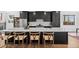 Bright open kitchen features a large island with counter seating and sleek black cabinets at 4454 Utica St, Denver, CO 80212