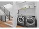 Spacious laundry room adjacent to a staircase with modern washer and dryer at 4454 Utica St, Denver, CO 80212